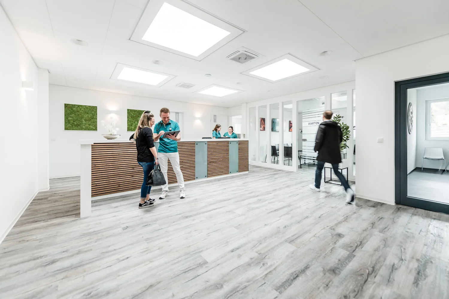 Zwei Patienten an der Anmeldung der Praxis