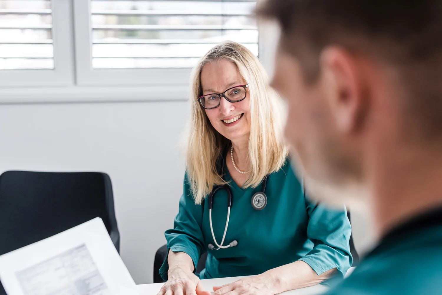 Ärztin bespricht einen Befund mit einem Patienten