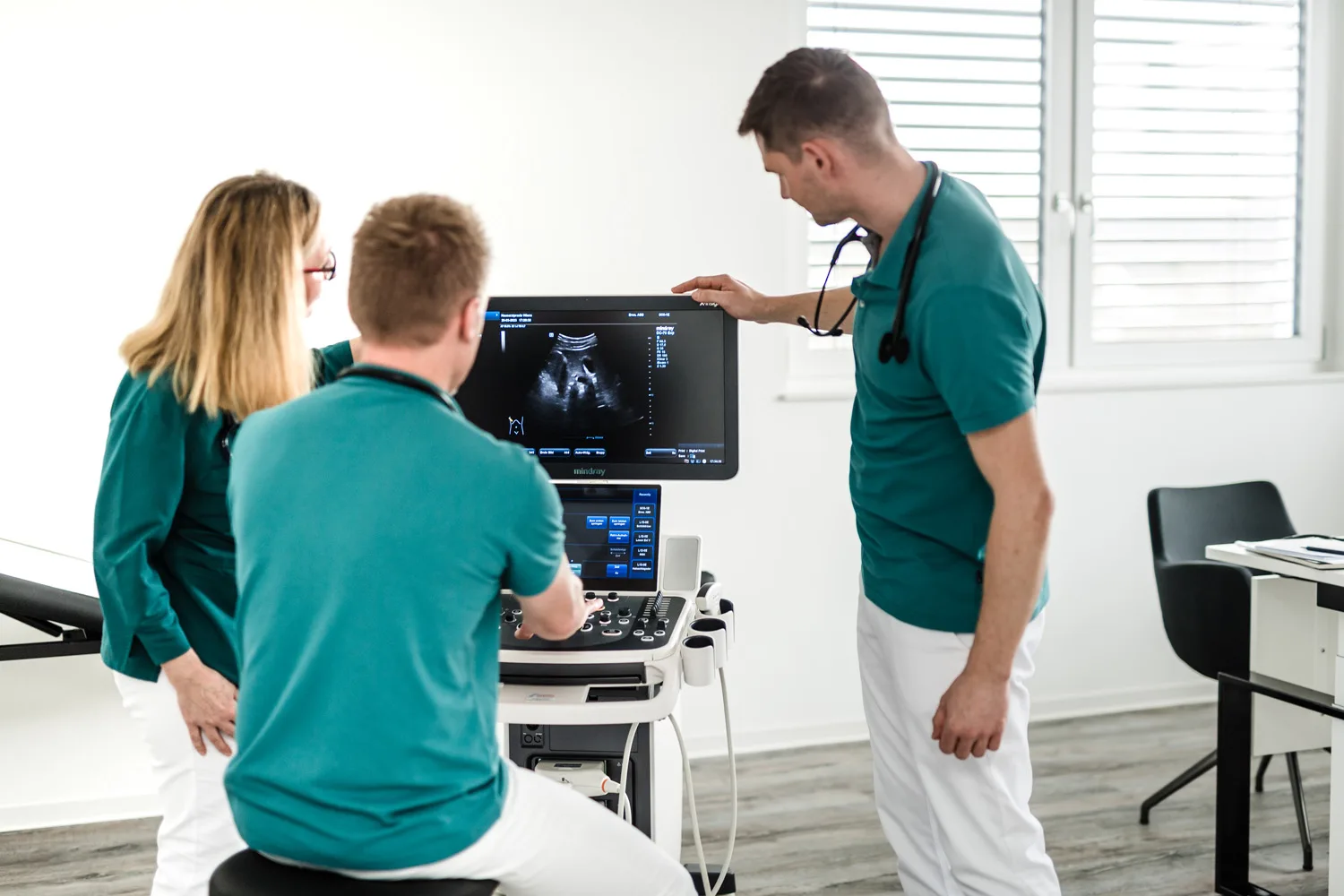 Drei Mitglieder des Teams am Ultraschallgerät